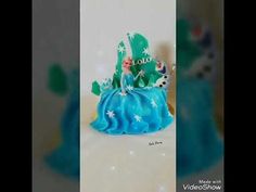 a frozen princess figurine sitting on top of a blue cake with white stars