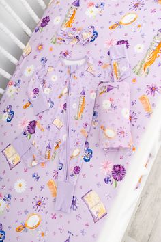 a baby's purple bedding with princesses on it