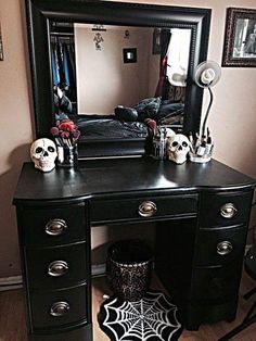 a black vanity with skulls on it and a mirror over the top that says halloween