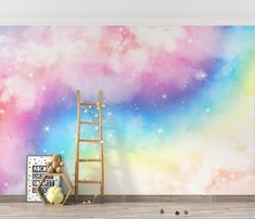 a room with a ladder and colorful wallpaper on the walls that has a space themed mural behind it