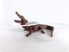 a small plastic animal with a glass plate on it's back legs and feet