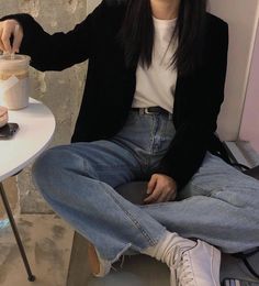 a woman sitting on a table with a cup in her hand