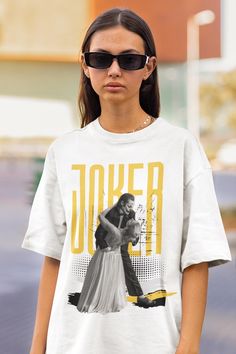 a woman wearing sunglasses and a t - shirt with the words joker printed on it