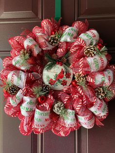 a christmas wreath on the front door decorated with candy canes and pineconis