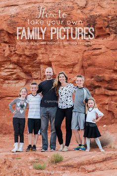 a family poses in front of a rock formation