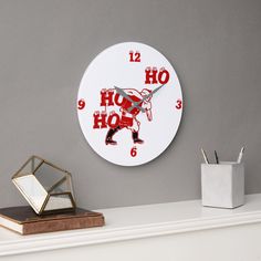 a clock that is on the wall next to a desk with a pen and mirror