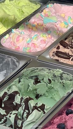 several different types of ice cream in trays with toppings on them, including green, pink and blue