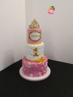 a three tiered cake with pink and gold decorations