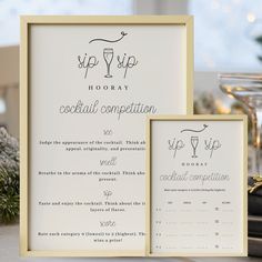 a table with a menu and wine glasses on it next to a framed sign that reads sip sip hooray cocktail competition