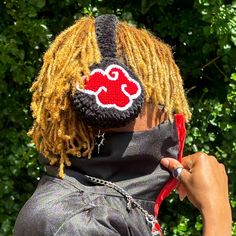 a woman with dreadlocks wearing a red and white face mask on her head