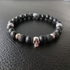 Elevate your style with this stunning handmade matte black onyx and lava rock bracelet, adorned with a Tibetan silver scalp charm. This one-of-a-kind piece is the perfect accessory for any occasion, making it an excellent choice for a unique gift for him or her. 🌟 Key Features:  ▪ Handcrafted with precision and care  ▪ Premium quality matte black onyx and lava rock beads  ▪ Tibetan silver scalp charm for a touch of uniqueness  ▪ Adjustable to fit most wrist sizes  ▪ Versatile enough for women and men 💖 Show your loved ones how much you care with this exquisite handmade bracelet. It's a meaningful way to express your feelings and create lasting memories. 🖤 Add a touch of sophistication to your style with the healing properties of matte black onyx and the grounding energy of lava rock. Th Handmade Onyx Black Bracelets, Handmade Black Onyx Bracelets, Minimalist Black Beaded Bracelets With Natural Stones, Minimalist Black Beaded Bracelet With Natural Stones, Spiritual Black Beaded Bracelets With Stones, Handmade Black Lava Stone Beaded Bracelets, Black Lava Stone Beaded Bracelets With Natural Stones, Spiritual Black Bracelets With Stones, Black Lava Stone Bracelets With Gemstone Beads