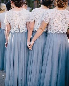 the bridesmaids are dressed in blue dresses and holding hands with each other as they walk down the street