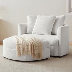 a living room with a white chair and ottoman on the floor next to a window