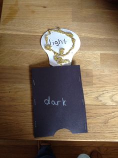 a wooden table topped with a piece of paper next to a sign that says light