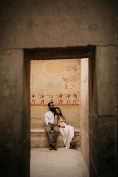 a man and woman sitting next to each other in front of an egyptian steet