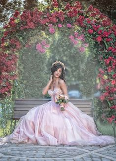 a woman in a pink dress sitting on a park bench with flowers around her head