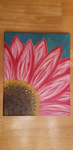 a painting of a pink flower on a wood floor