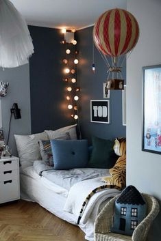 a bedroom decorated in blue and white with hot air balloons hanging from the ceiling above