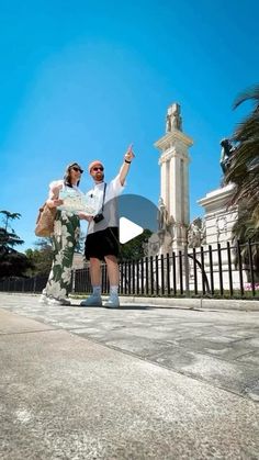 a man and woman standing in front of a tall building