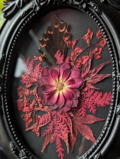 a close up of a clock with flowers and leaves on the front cover, in an ornate frame