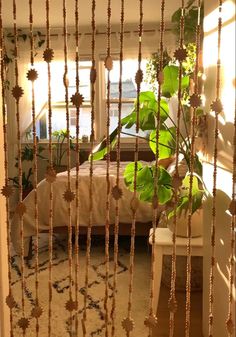 a bed sitting next to a window covered in green leafy plants on top of a rug