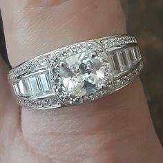 This Stunning Cubic Zirconia Ring Set In 925 Sterling Silver Has A Large Center Square Stone Surrounded By 16 Small Round Stones. Along Each Side Is A Row Of 4 Baguettes With A Row Of 6 Small Round Stones Above And Below The Row Of Baguettes. Beautiful And Stunning. Retails For $150. Cubic Zirconia Baguette-cut Jewelry With Center Stone, Baguette Cut Cubic Zirconia Jewelry With Center Stone, Silver Baguette-cut Ring With Halo Design, Cubic Zirconia Baguette Cut Jewelry In Halo Setting, Baguette Cut Cubic Zirconia Jewelry With Halo Setting, Silver Baguette Cut Halo Ring Gift, Silver Jewelry With Halo Setting In White Topaz, Silver Baguette Cut White Topaz Jewelry, Sterling Silver Jewelry With Baguette Cut Halo Setting