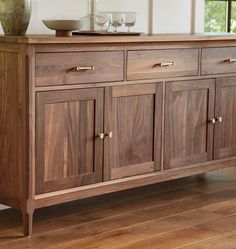 a wooden sideboard with two bowls on top