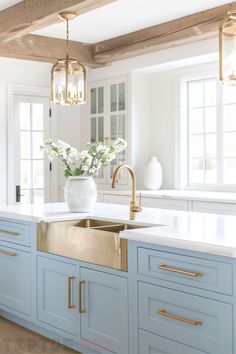 light blue island copper farmhouse sink gold faucet exposed wood beams gold light fixtures wood floor double bowl modern kitchen design Farmhouse Sink Ideas, Gold Light Fixtures, Copper Kitchen Sink Farmhouse, Gold Sink, Bus Build, Copper Farmhouse Sink, Contemporary White Kitchen, Glossy Kitchen, Blue Kitchen Designs