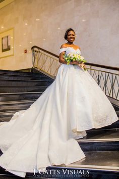 a woman in a wedding dress standing on some stairs