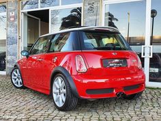 a small red car parked in front of a building