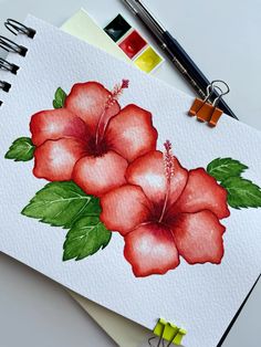 a drawing of two red flowers with green leaves on it next to markers and pencils