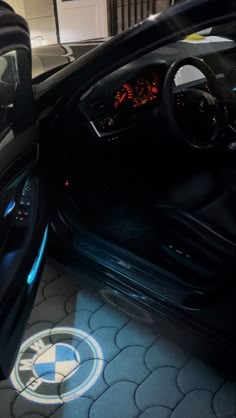 the interior of a car is shown with its door open and dashboard lights glowing on