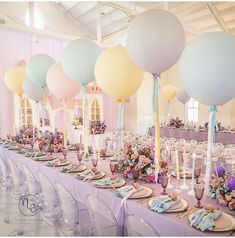 a long table is set with balloons and place settings for an elegant wedding breakfasteon