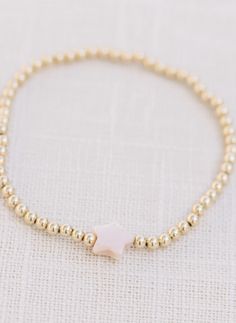 Handcrafted stretch bracelet made with a light pink mother of pearl bead and 14k gold filled 3mm beads made by artists in the USA length: 6.5 inches Dainty Adjustable Pearl Stretch Bracelet, Adjustable Hand-strung 14k Gold Filled Stretch Bracelet, Dainty Hand-strung Stretch Bracelet, Dainty Gold Stretch Bracelet With Gold Beads, Dainty 14k Gold-filled Stretch Bracelet With Gold Beads, Dainty Gold Bead Stretch Bracelet, Dainty 14k Gold-filled Stretch Bracelet, Adjustable Pink Beaded Bracelets In 14k Gold, Dainty Pink 14k Gold-filled Bracelets