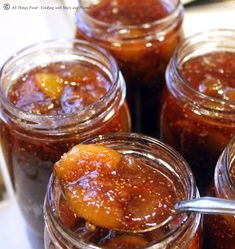 several jars filled with different kinds of food and one has a spoon sticking out of it