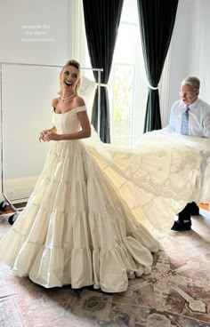 a woman in a wedding dress standing next to a man