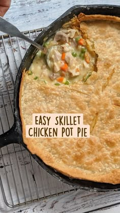 a skillet filled with chicken pot pie sitting on top of a metal rack next to a spatula