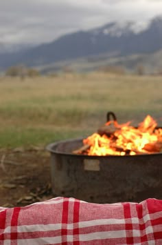 a person sitting in front of a fire pit with the words dis nawek