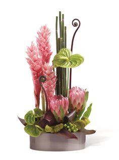 an arrangement of pink flowers and green plants