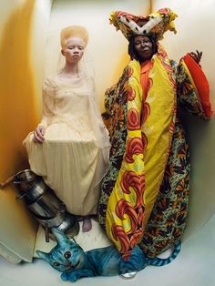 two people dressed in costumes sitting on a chair