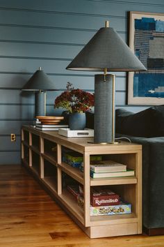 a living room with a couch, lamp and bookshelf on the side table