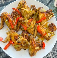 chicken with peppers and onions on a white plate