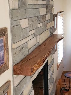 a stone fireplace in a living room next to a window