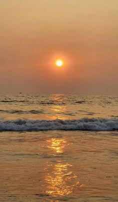 the sun is setting over the water at the beach