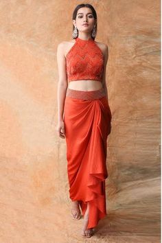 Orange skirt with draped detail and embroidered waistband paired with halter top.
Components:2
Embroidered
Neckline:Halter neck
Sleeve Length:Sleeveless
Fabric:Crepe Satin
Color:Orange
Embroidered top - Aza Fashions Haldi Clothes, Halter Top Outfit Ideas, Halter Neck Blouse Design, Navratri Ideas, Blouse With Skirt, Black Saree Blouse, Halter Neck Blouse, Halter Top And Skirt, Halter Neck Blouses