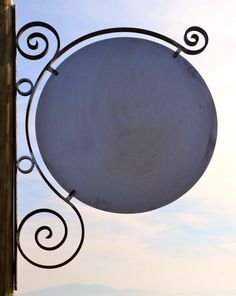 a white sign hanging from the side of a metal pole