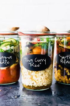 three jars filled with different types of food on top of a table next to each other