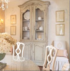 a dining room table with chairs and a china cabinet