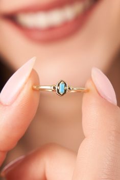 a close up of a person holding a ring with a stone on the middle of it