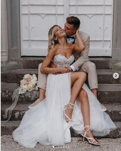 a man and woman are sitting on the steps in front of a white door together